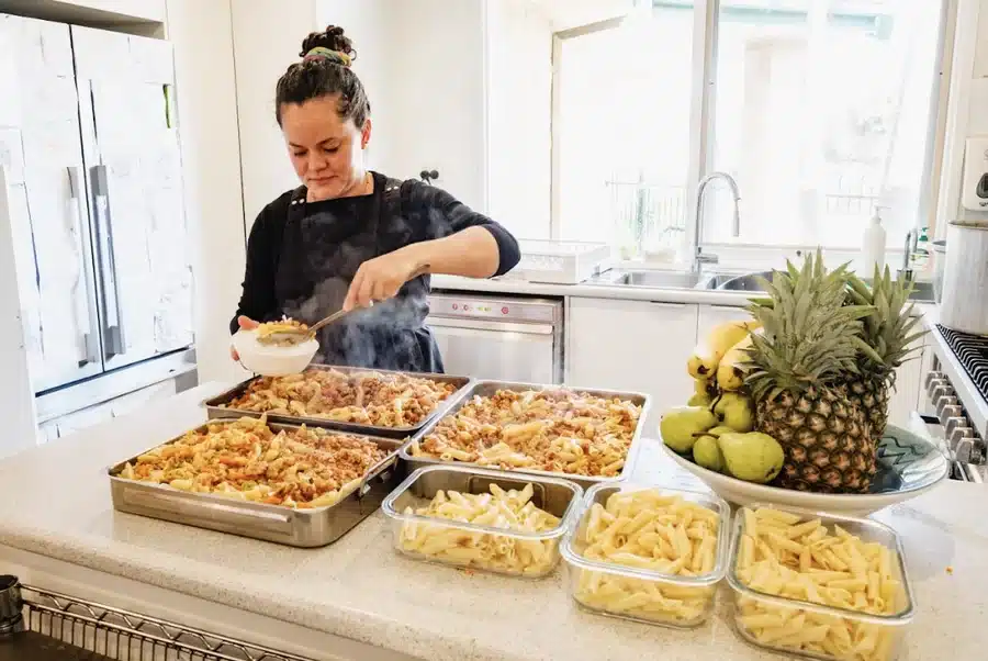 An educator preparing healthy meals and fresh fruit in the kitchen