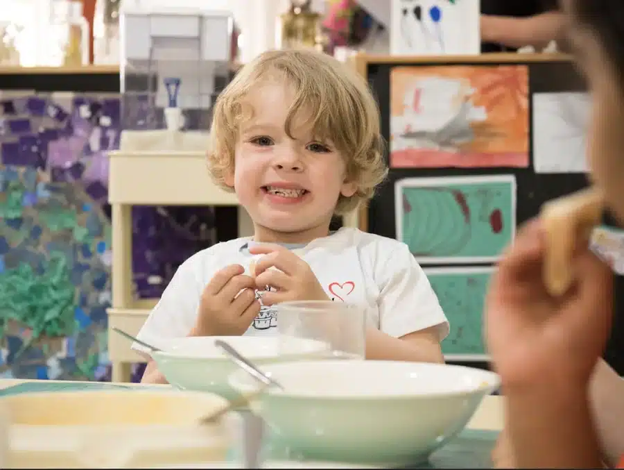 A happy child taking part in a hands-on cooking and sensory activity