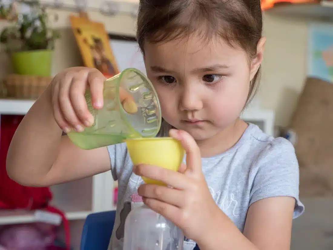 Child pouring water during a Montessori practical-life activity